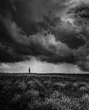 Black and white storm with person in meadow